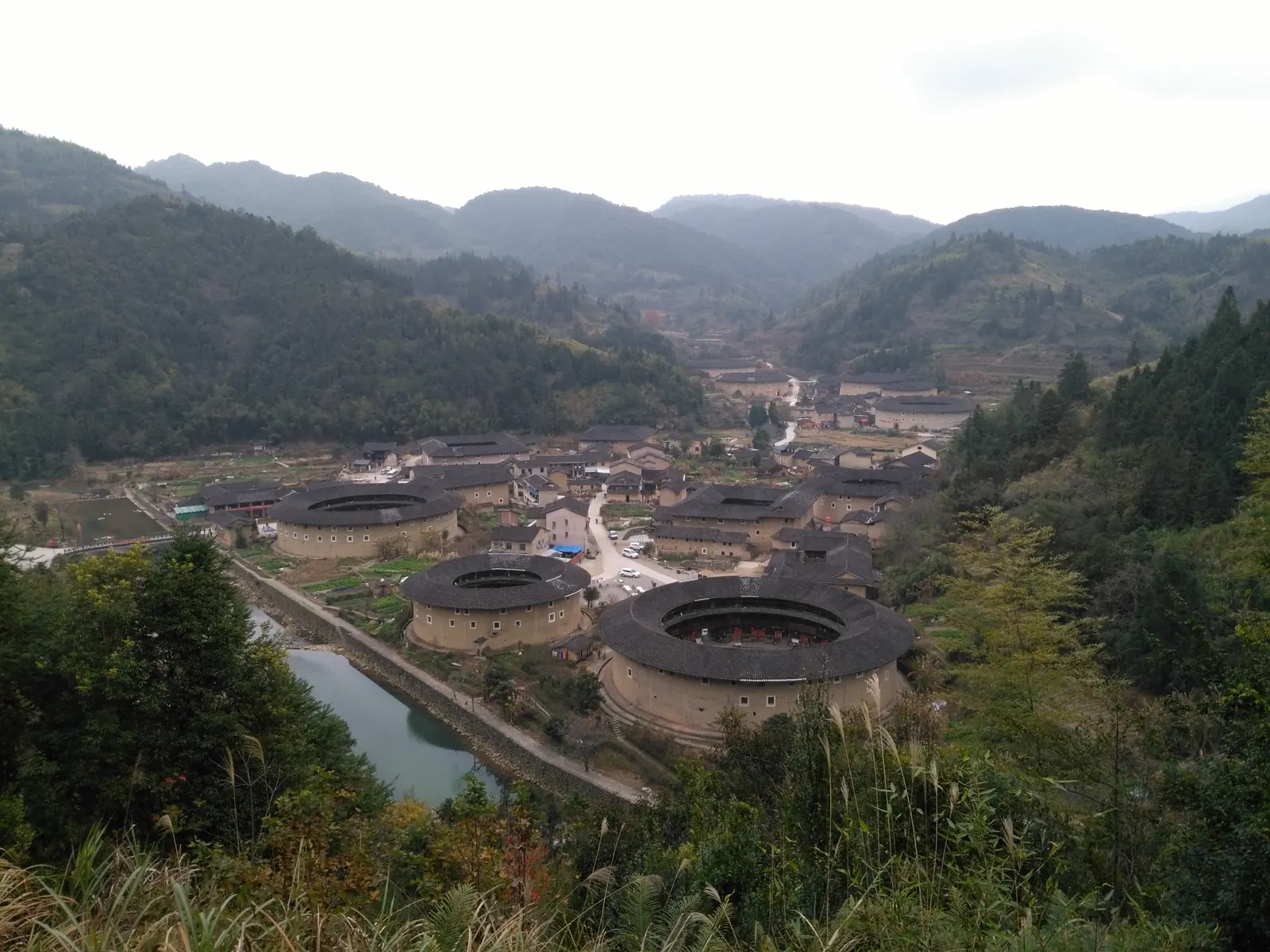 A birds-eye view of a Fujian tulou: the rammed-earth ring, courtyards, and tiled roofs read as one concentric composition.