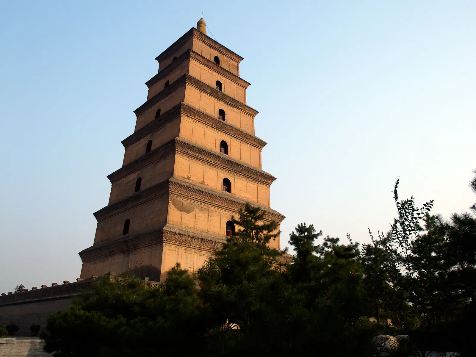 The seven-story brick Giant Wild Goose Pagoda in warm evening light above the temple trees.