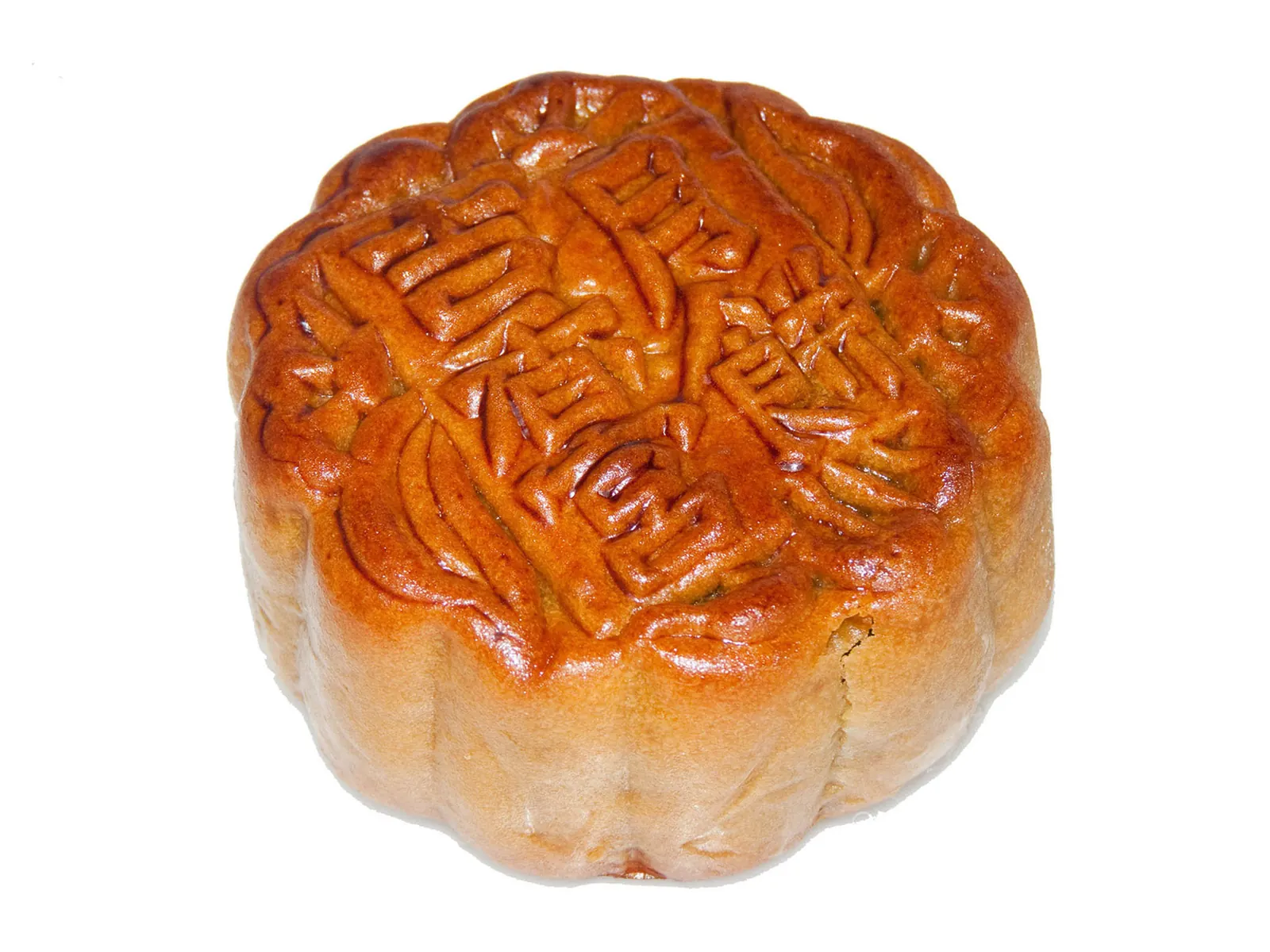 A golden mooncake with crisp stamped relief pattern, photographed whole on a white ground.