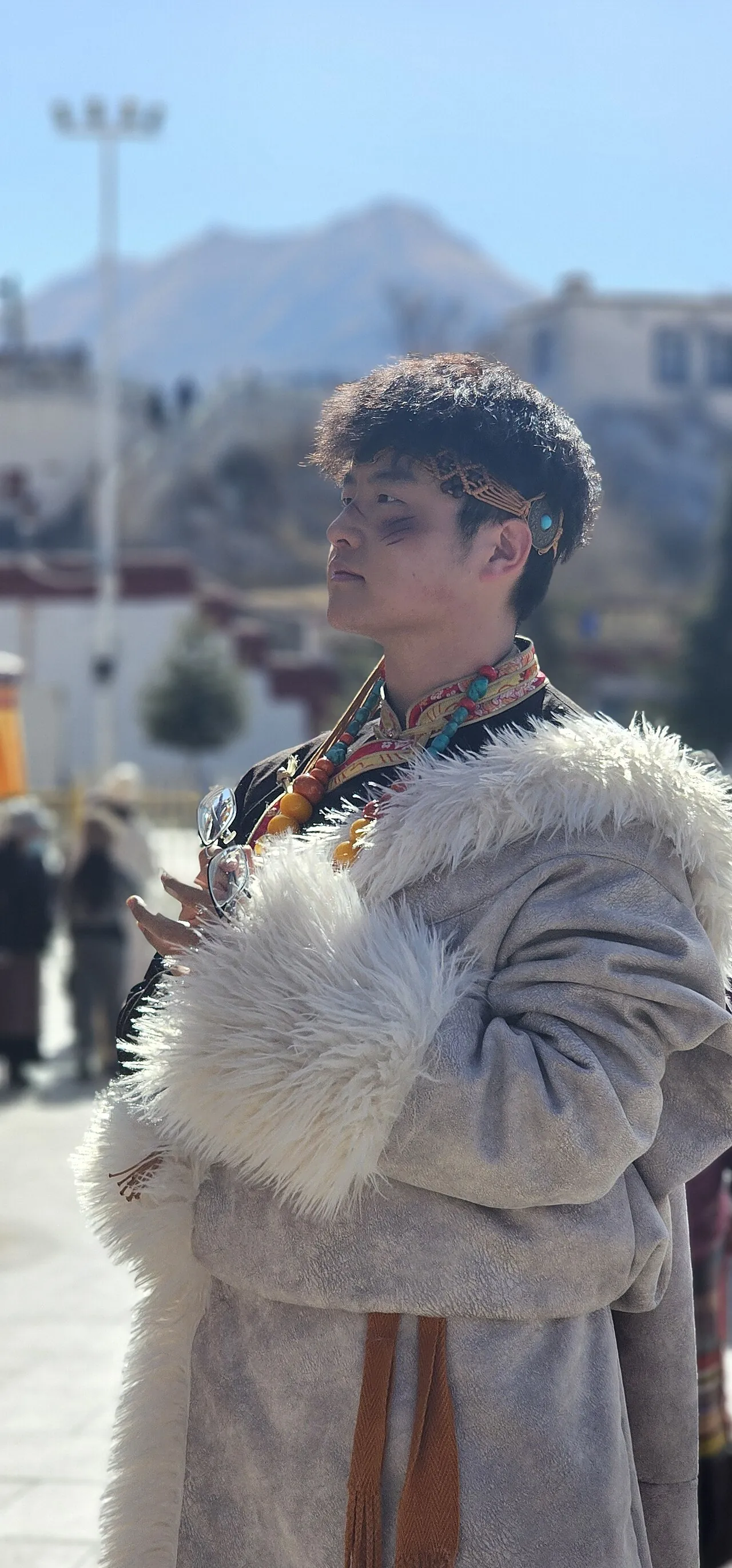 People in traditional Tibetan costume gathering near the Potala Palace.