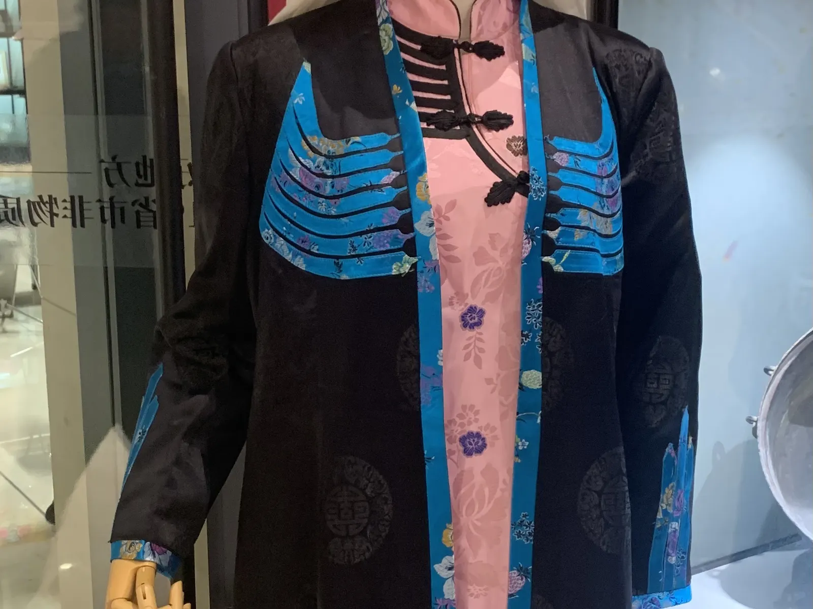 The Yutian tarryilik: a black-and-white winged outer robe of Uyghur dress over patterned layers.