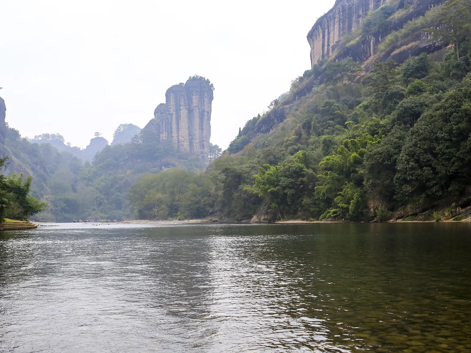 Jade Peak rising above the Nine-Bend Stream at Wuyi, its reflection flat in the green water.